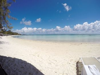 Scenic view of beach against cloudy sky