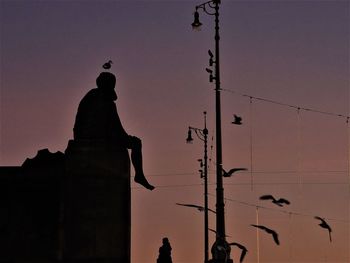 Low angle view of silhouette statue against sky