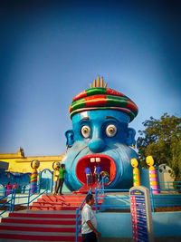 Low angle view of sculpture against blue sky