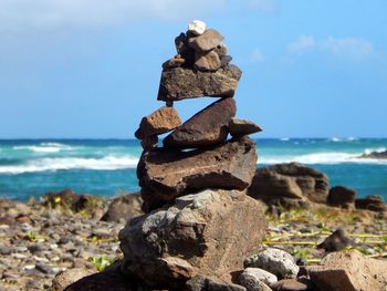Stack of rocks on beach against sky