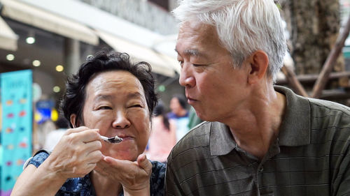 Cute smiling old couple eating ice cream 