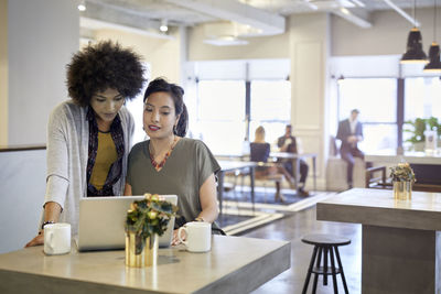 Businesswomen using laptop computer while working in office