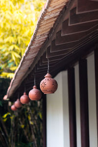 Low angle view of decorations hanging from rooftop against trees