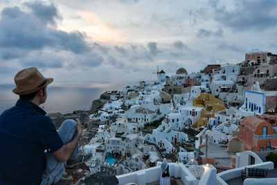 Man standing by sea against buildings in city