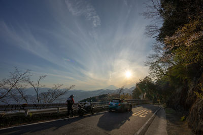 Cars on road against sky in city