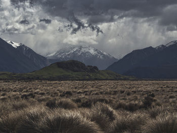 Scenic view of field and mountains against sky