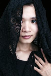 Portrait of woman with scarf against black background