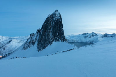 Snow covered mountain against blue sky