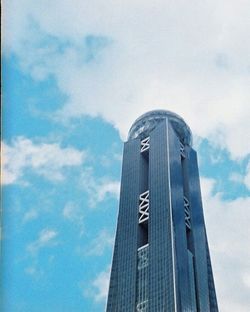 Low angle view of skyscrapers against cloudy sky