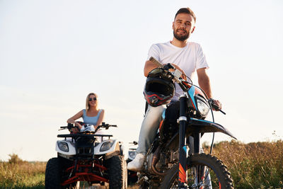 Side view of man riding motorcycle on field