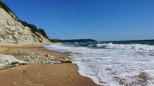 Scenic view of beach against clear blue sky