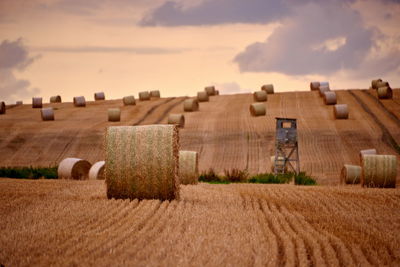 Hay bales on field against sky