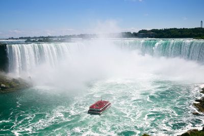 Scenic view of waterfall against sky