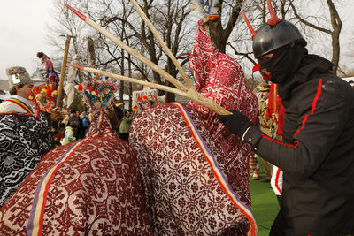 Person in costume holding stick by decoration during event