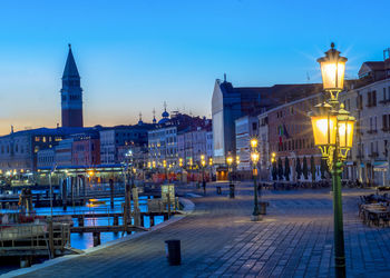 Illuminated buildings in city at dusk