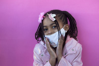 Portrait of cute girl against pink background