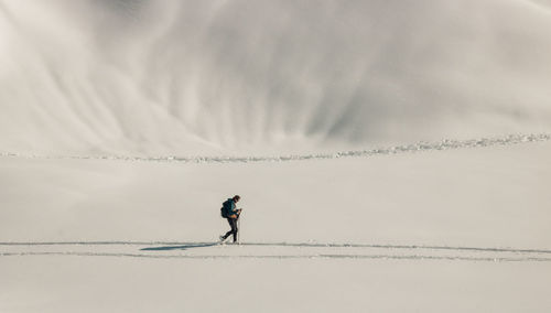 Hiker walking in the snow on the peaks of chamrousse in the alps in isère in france