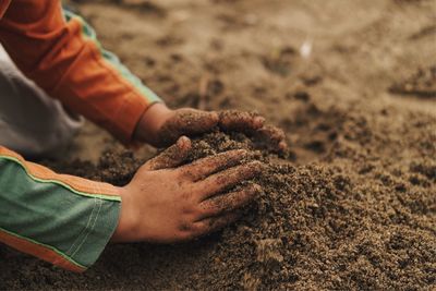 Close-up of boy playing with sand