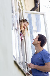 Young couple painting windows, stockholm, sweden