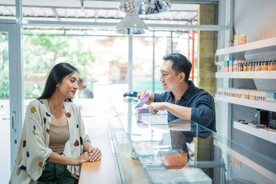 Side view of female friends standing in store