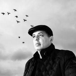 Low angle view of man flying against sky