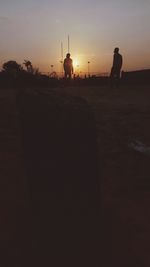 Silhouette of people on street during sunset