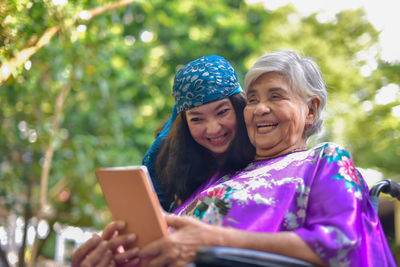 Portrait of smiling girl using smart phone outdoors