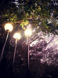 Low angle view of illuminated street light against sky