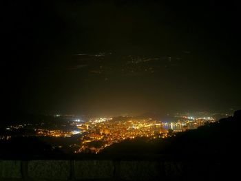 Illuminated cityscape against sky at night