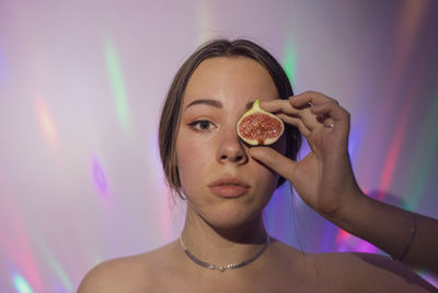 Portrait of woman holding fig