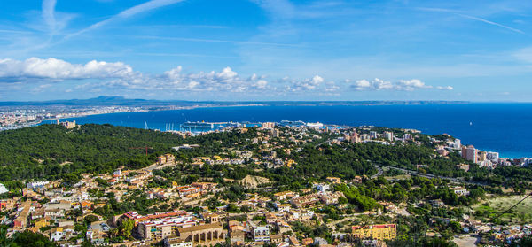 High angle view of town by sea against sky