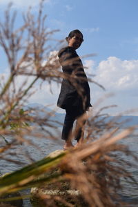 Man standing by sea against sky
