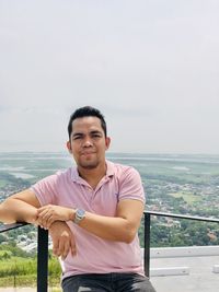 Portrait of young man standing against sea