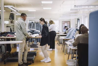 Male and female design professionals working in workshop