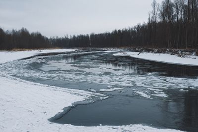 Scenic view of frozen lake against sky during winter