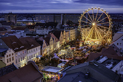 High angle view of illuminated ferris wheel in city at night
