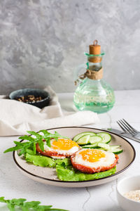 Tomatoes baked with egg and greens on a plate on the table. homemade lunch. vertical view