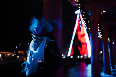 Woman looking at illuminated stage at night