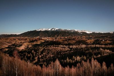 Scenic view of landscape with snowcapped mountains against clear sky