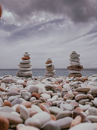 Stack of stones on beach against sky