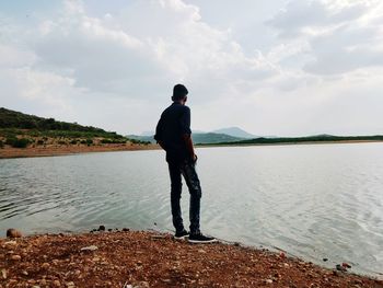 Full length of man standing on beach against sky