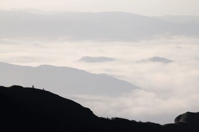 Scenic view of mountains against cloudy sky