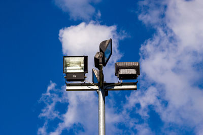 Low angle view of floodlight against cloudy sky