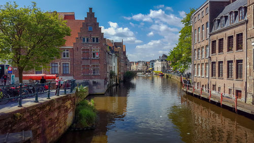 Canal amidst buildings in city against sky