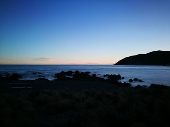 Scenic view of sea against clear sky at sunset