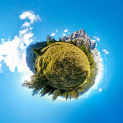 Digital composite image of trees against blue sky