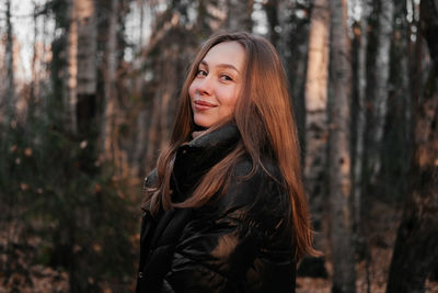 Portrait of young woman standing in forest