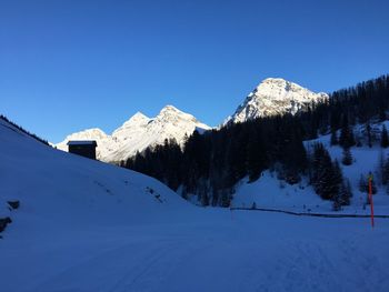 Scenic view of snowcapped mountains against clear blue sky