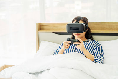 Man using mobile phone on bed at home