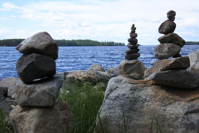 Stack of stone by lake against sky